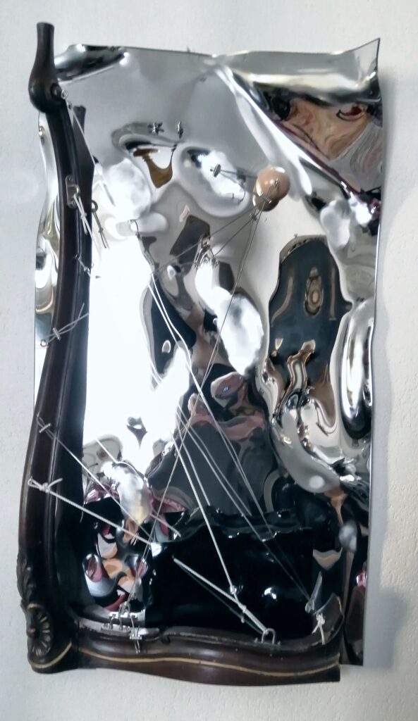 "Issa le vele che il mare affrontiamo, la Luna ce la portiamo" (22 marzo/ 16 aprile 2026) cm 50 x 90 Lastra di plexiglass a specchio termodeformato con inserita una struttura lignea, funi tiranti e lastra plexiglass nero deformato ed una sfera.